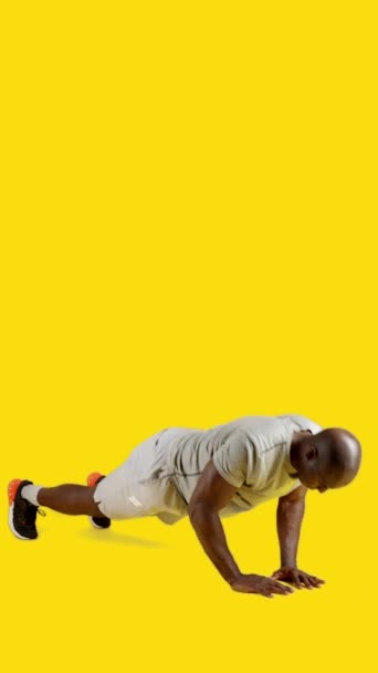 強いアフリカ人の男の黄色の背景を持つスタジオでビデオを密接に上にプッシュ — ストック動画