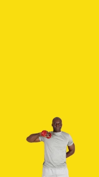 Wideo Studio Żółtym Tłem Afrykańskiego Mężczyzny Wykonującego Ćwiczenia Rozciągające Tricepsy — Wideo stockowe