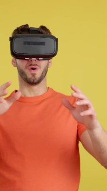 Sanal gerçeklik gözlüklü, sarı arka planlı mutlu beyaz adam.