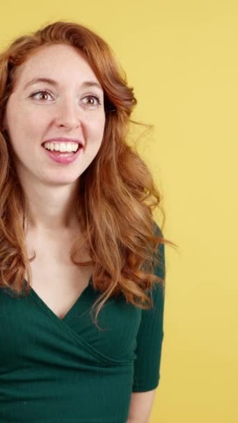 黄色の背景を持つスタジオで贈り物を受けながら クールな赤毛の女性の笑顔 — ストック動画