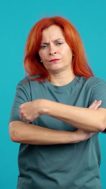 Зрелая Рыжая Женщина Скрещивающая Руки Сердитым Выражением Лица Студии Синем — стоковое видео