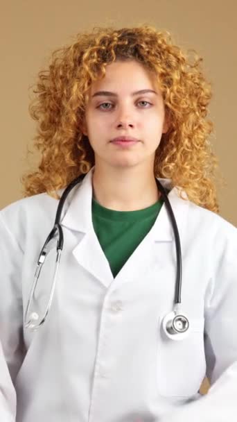 Vídeo Estudio Una Joven Doctora Seria Con Pelo Rizado Bata — Vídeos de Stock