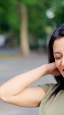 Two caucasian friends talking closely while smiling in the street