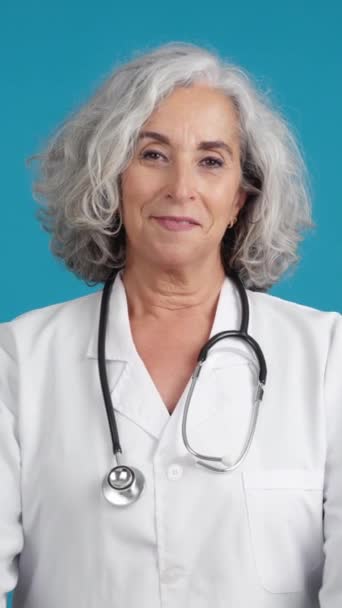 Studio Video Blue Background Mature Friendly Doctor Posing Lab Coat — Vídeo de Stock