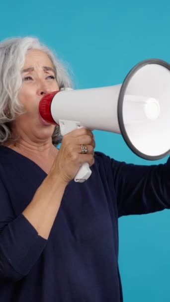 Студійне Відео Синім Тлом Засмученої Зрілої Жінки Протестує Мегафоном — стокове відео