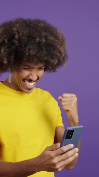 Захоплений Африканський Чоловік Кучерявим Волоссям Святкування Під Час Використання Мобільного — стокове відео