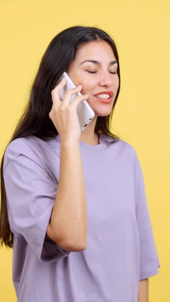 Здивована Іспаномовна Жінка Розмовляє Мобільним Телефоном Студії Жовтим Фоном — стокове відео