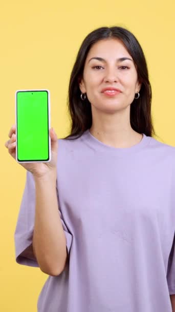 Happy Woman Holding Mobile Chroma Screen Studio Yellow Background — 图库视频影像