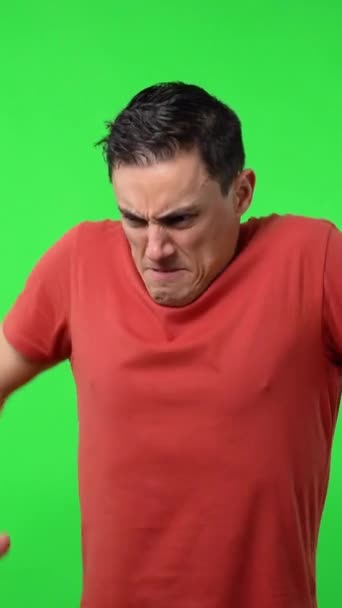 必死に叫んでる男 赤いシャツを着て 中発だ クロマグリーンの背景 — ストック動画