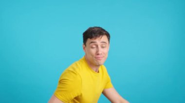 Stüdyoda bir adamın mavi arkaplanlı videosu var. Bir başparmağını kaldırıyor, alkışlıyor ve merdivenlerden inip çıkıyor.