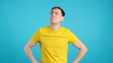 Stüdyoda mavi arka planı olan düşünceli bir adamın bir çözüm bulmaya çalıştığı bir video.