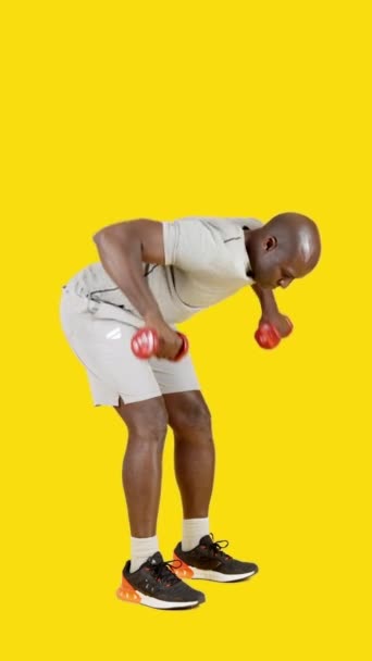 Film Studio Żółtym Tłem Silnego Afrykanina Wykonującego Ćwiczenia Wioślarskie Hantlami — Wideo stockowe