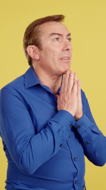 Reifer Mann Betet Mit Gefalteten Händen Studio Mit Gelbem Hintergrund — Stockvideo