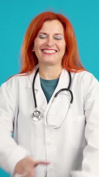Sonriente Madura Pelirroja Doctora Pie Con Los Brazos Cruzados Estudio — Vídeos de Stock