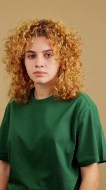 Studio video of a serious young woman with curly hair gesturing with her hand prohibition