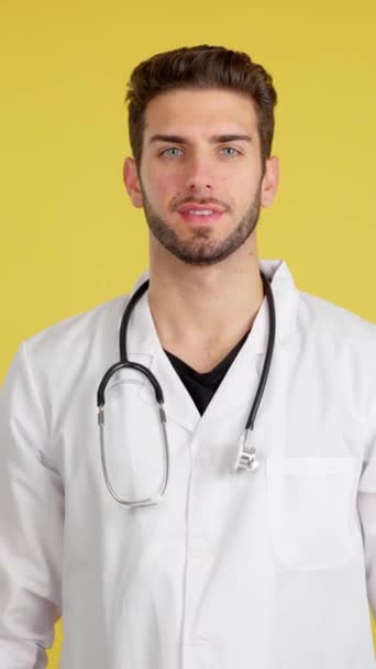 Kameraya Gülümseyen Beyaz Bir Doktor Stüdyoda Kolları Çaprazlanmış Sarı Arka — Stok video