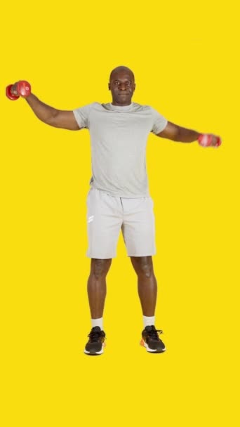 Wideo Studiu Żółtym Tłem Afrykańskiego Mężczyzny Wykonującego Izometryczne Boczne Ćwiczenia — Wideo stockowe