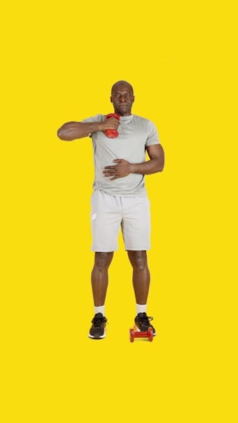 Video Studio Med Gul Bakgrund Afrikansk Man Gör Triceps Sidoförlängningsövningar — Stockvideo