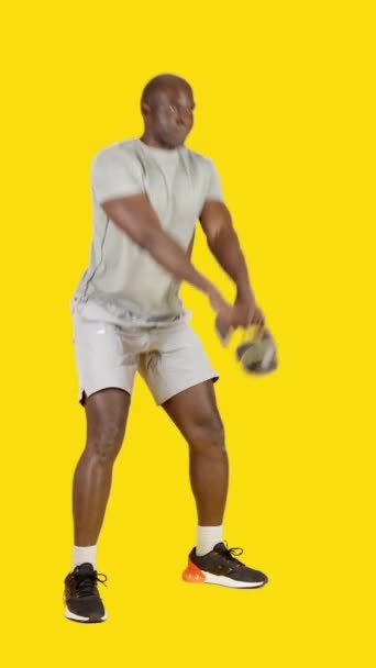 Wideo Studio Żółtym Tłem Silnego Afrykanina Robi Swing Exercise Kettlebell — Wideo stockowe