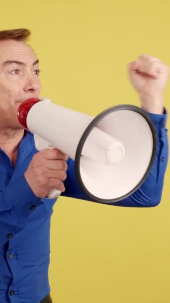 Rozrušený Dospělý Muž Křičí Pomocí Reproduktoru Studiu Žlutým Pozadím — Stock video
