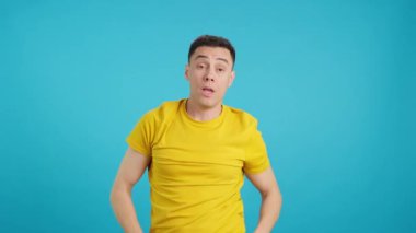 Stüdyoda uyuyan bir adamın mavi arkaplanlı videosu uyanır ve vücudunu uzatır.