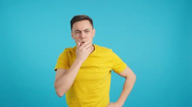 Stüdyoda düşünceli bir adamın mavi arkaplanlı videosu iyi bir fikirle ve gülümsemeyle ortaya çıkar..