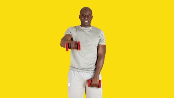 Wideo Studiu Żółtym Tłem Afrykańskiego Mężczyzny Wykonującego Alternatywne Ćwiczenia Podnoszenia — Wideo stockowe