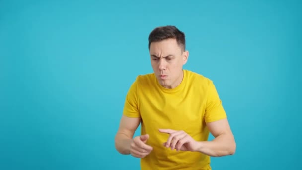 Stüdyoda Mavi Arka Planı Olan Bir Adam Görünüyor Parmaklarına Güveniyor — Stok video