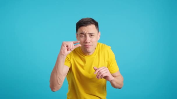 Video Ateliéru Modrým Pozadím Muže Gestikulujícího Malé Množství Prsty — Stock video