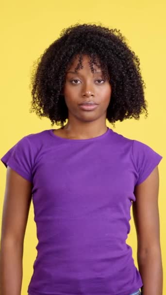 非洲裔妇女在有黄色背景的演播室用大拇指举手表决赞成 — 图库视频影像