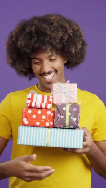 Smiley Africký Muž Kudrnaté Vlasy Drží Mnoho Darů Při Pohledu — Stock video