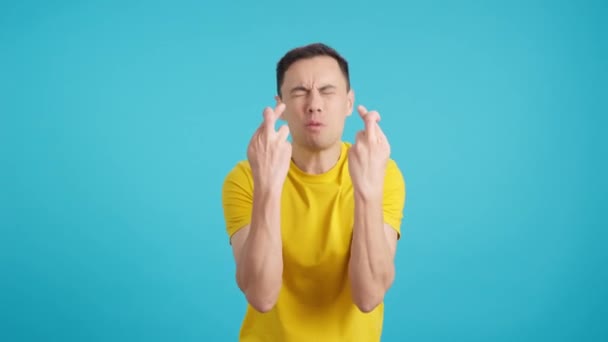 Video Estudio Con Fondo Azul Hombre Cruza Los Dedos Deseando — Vídeo de stock