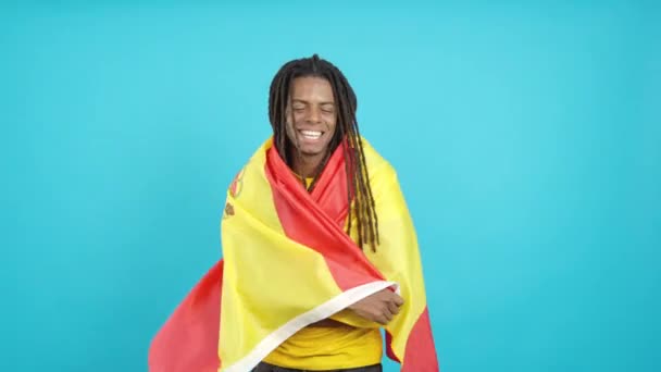 Счастливый Латиноамериканец Дредами Завернутый Испанский Национальный Флаг Студии Синем Фоне — стоковое видео