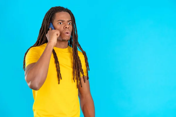 Rastalı Latin Bir Adam Stüdyoda Mavi Arka Planlı Cep Telefonuyla — Stok fotoğraf