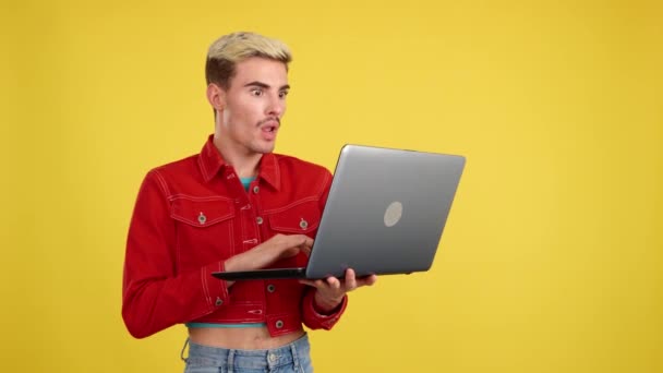 Stylowy Zaskoczony Gej Człowiek Pomocą Laptop Studio Żółty Tło — Wideo stockowe