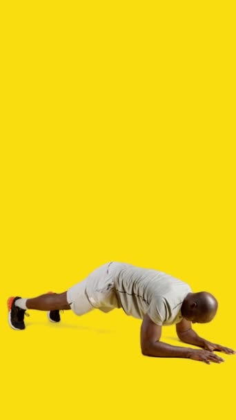Film Studiu Żółtym Tłem Sportowego Afrykanina Ćwiczącego Deskę Podłodze — Wideo stockowe