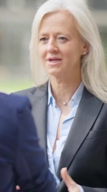 Yetişkin bir iş kadınının diğer iş kadınlarıyla el sıkışırken çekilmiş yavaş çekim videosu.