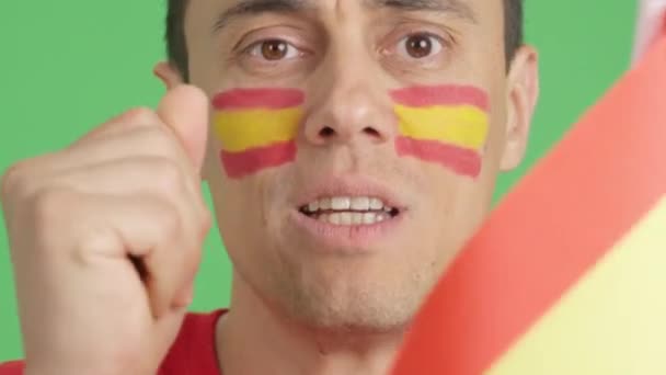 在演播室里用彩色照片近距离拍摄一个脸上挂着西班牙国旗的非常紧张的男人 在一场比赛中支持西班牙球队 这场比赛最终以失败告终 — 图库视频影像