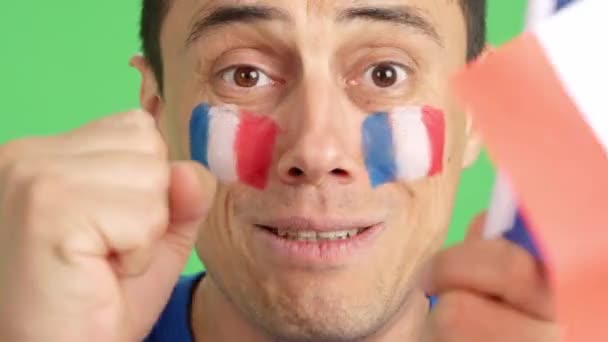 在演播室里用彩色的近距离录像拍摄了一个脸上挂着法国国旗的非常紧张的人 他在一场艰难的比赛中为法国队提供了支持 这场比赛最终以失败告终 — 图库视频影像