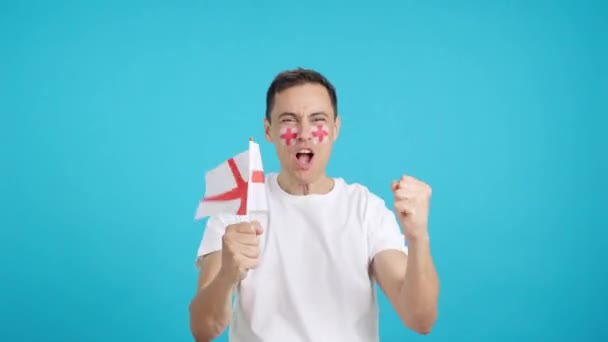 影片在演播室里 一个英国支持者高喊着 挥动着国旗 欢呼他的球队胜利 热烈庆祝胜利 — 图库视频影像