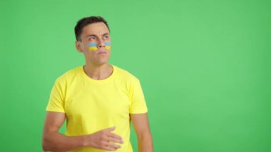 Stüdyoda, Ukraynalı bir vatanseverin, ulusal marşı ciddiyetle dinlediği bir video.