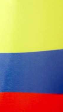 Kolombiya bayrağının rüzgarla dalgalandığı stüdyoda dikey yavaş çekim videosu