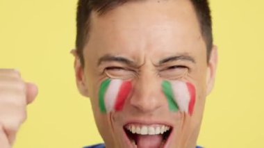 Stüdyoda, yüzünde İtalyan bayrağı olan ve İtalyan takımını destekleyen bir adamın krom görüntüsü var.