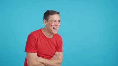 Stüdyoda, yüzünde İsviçre bayrağı olan mutlu bir adamın krom görüntüsüyle fotokopi odasına boş bir şekilde bakıyor.