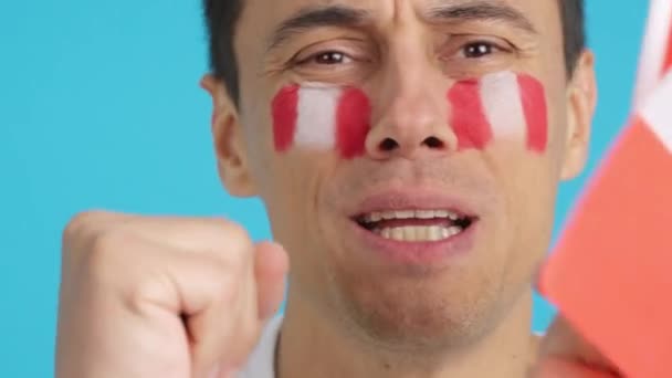 在演播室里用彩色照片近距离拍摄一个脸上挂着秘鲁国旗的非常紧张的男人 在一场比赛中支持着秘鲁球队 这场比赛最后以失败告终 — 图库视频影像