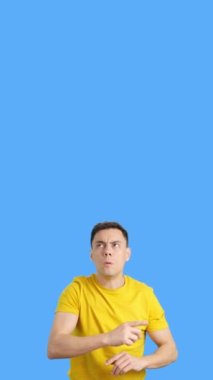 Kafası karışık, yetişkin bir beyaz adamın mavi arka planlı videosu tereddüt ediyor.