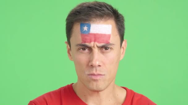 カメラを見ている顔にチリの旗が描かれた深刻な男のクロマのスタジオでのビデオ — ストック動画