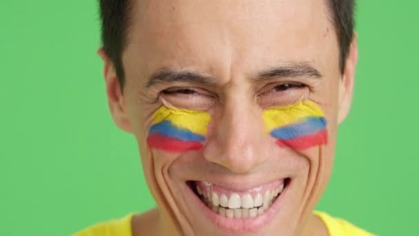 摄影棚里的录像 彩色的是一个男人的特写 他的脸上挂着科洛曼语的旗帜 在镜头前微笑 — 图库视频影像