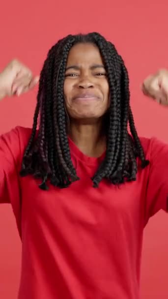 Szczęśliwa Afrykańska Kobieta Świętuje Podnosząc Ramiona Studiu Czerwonym Tłem — Wideo stockowe