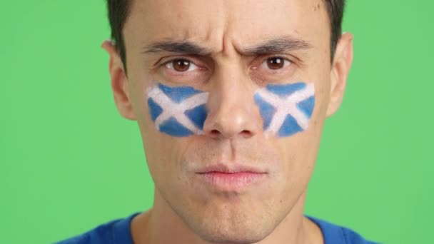 カメラを見ている顔にスコットランドの旗が描かれた深刻な男のクロマのスタジオでのビデオ — ストック動画